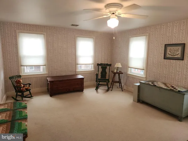a living room with furniture and a ceiling fan