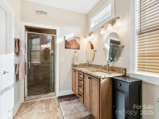 a bathroom with a granite countertop sink mirror and a shower