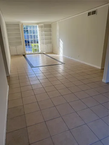 a view of an empty room and chandelier