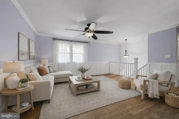 a view of a livingroom with a flat screen tv ceiling fan and hardwood floor