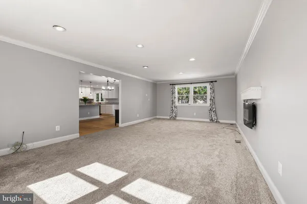 a spacious bedroom with a bed a chandelier and a dresser