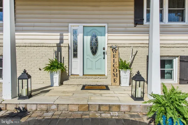 a kitchen with stainless steel appliances granite countertop a refrigerator a stove top oven a sink dishwasher and white cabinets with wooden floor