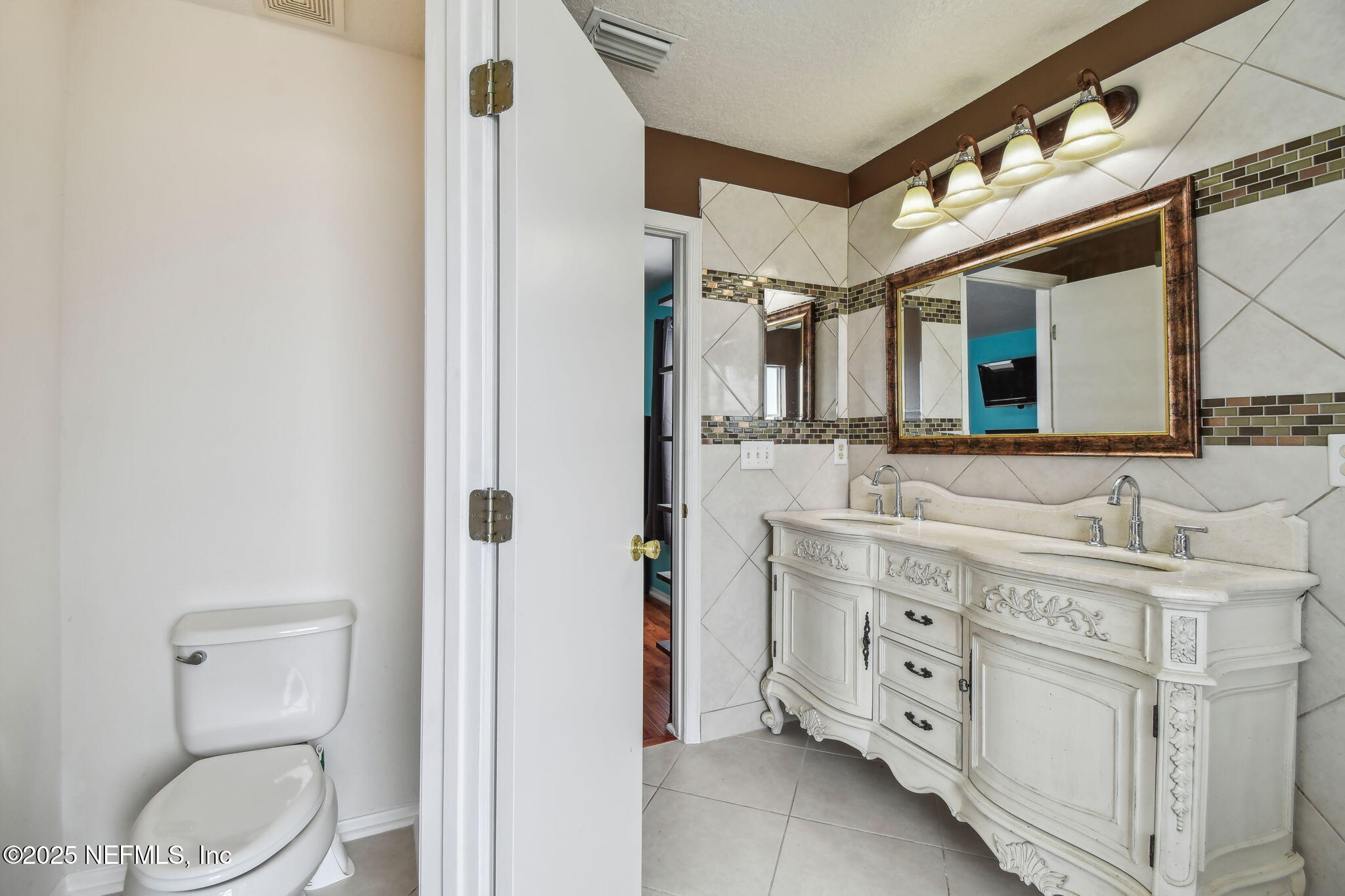 116 Nunna Rock Trail St. Augustine, FL 32092 - Photo 53 of 111 a spacious bathroom with a toilet sink and mirror