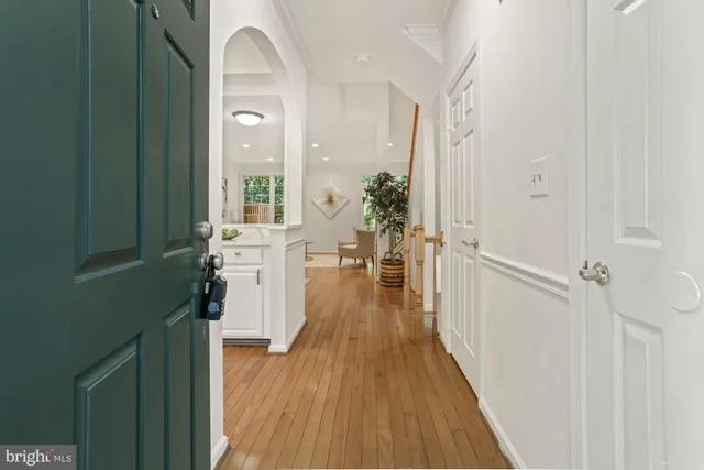 a view of a hallway with wooden floor and staircase