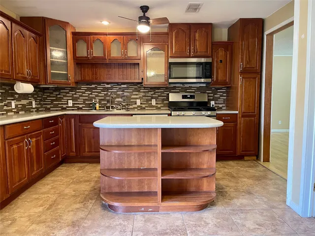 a kitchen with stainless steel appliances granite countertop a stove microwave and cabinets