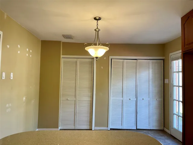a view of a hallway with a chandelier fan