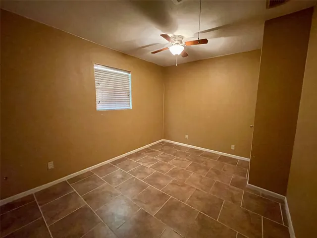 a view of an empty room with a chandelier fan