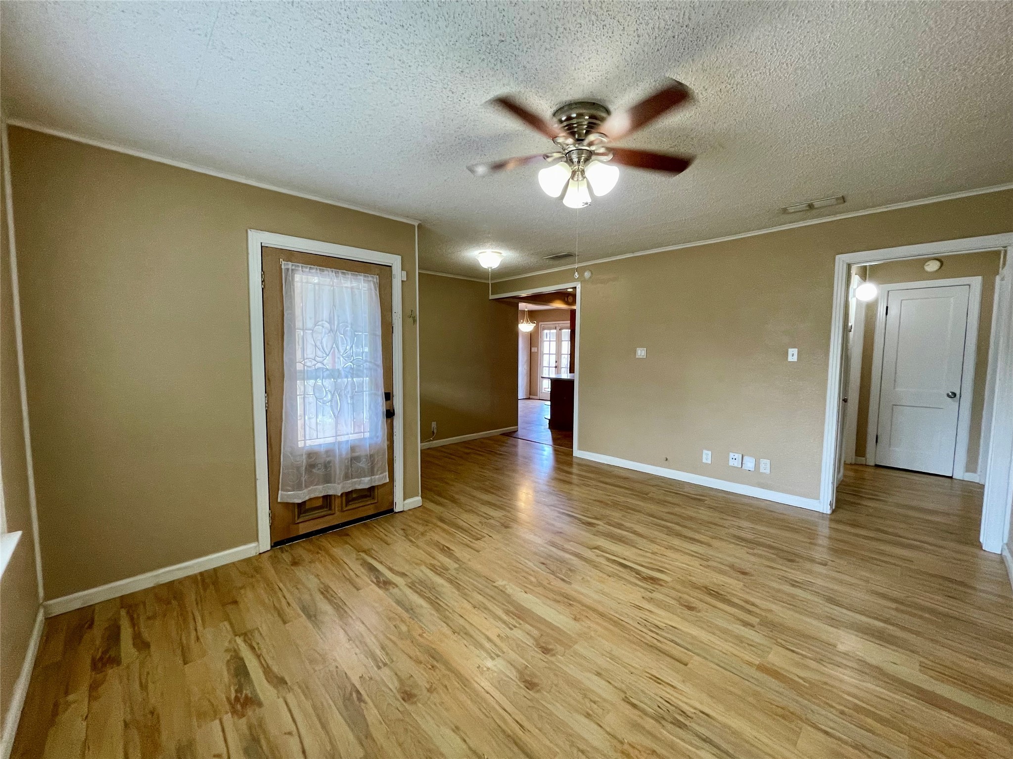 1113 Chevy Chase Drive Angleton, TX 77515 - Photo 5 of 32 a view of an empty room with wooden floor and a window