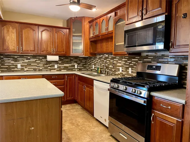 a kitchen with stainless steel appliances granite countertop a stove microwave and sink