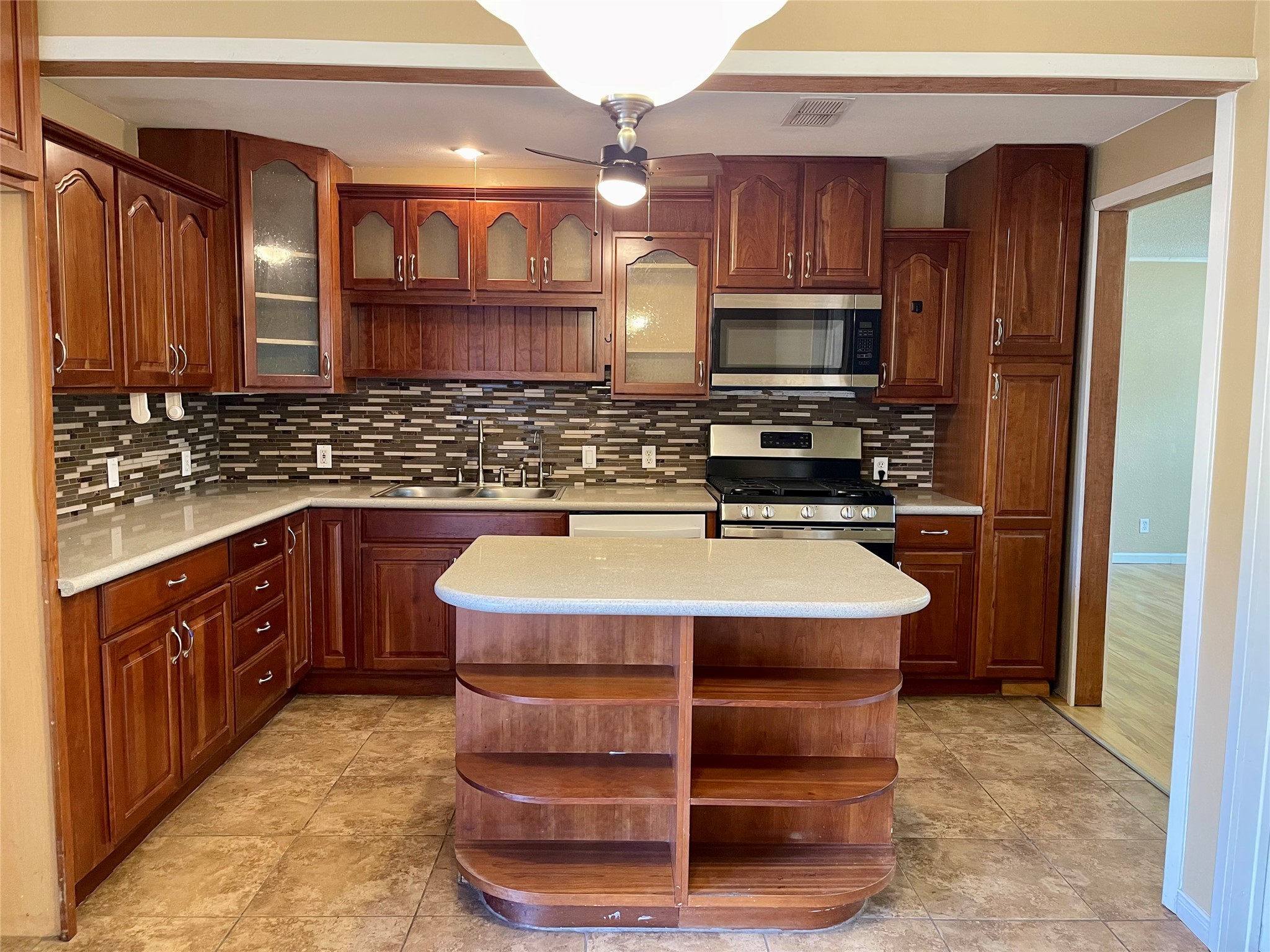 1113 Chevy Chase Drive Angleton, TX 77515 - Photo 10 of 32 a kitchen with kitchen island granite countertop a sink stove and cabinets