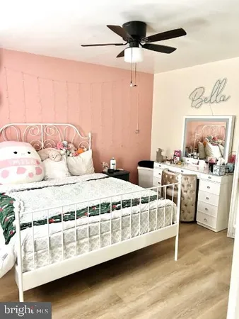 a bedroom with a bed a couch and a painting on the wall
