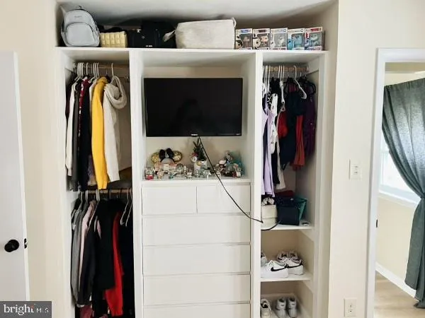 a view of walk in closet with clothes and shoes