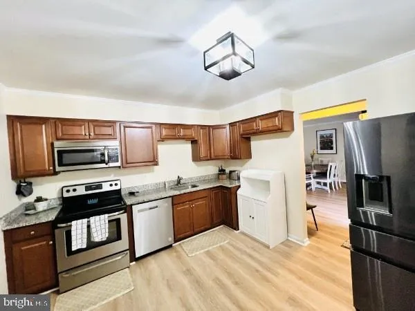 a kitchen with stainless steel appliances granite countertop a stove refrigerator and microwave