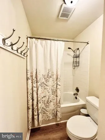 a bedroom with a bed closet and wooden floor