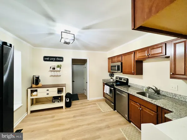 a large kitchen with stainless steel appliances granite countertop a stove a sink and a refrigerator