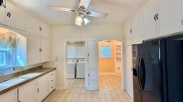 a kitchen with a refrigerator a sink and cabinets