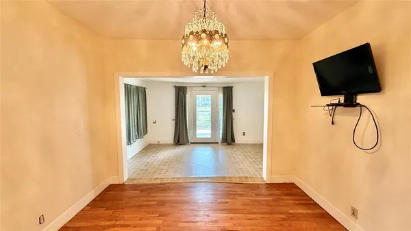 a view of a livingroom with wooden floor and a chandelier