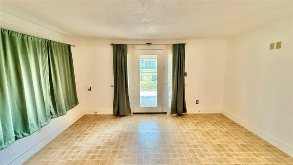 a view of an empty room with window and a bathroom
