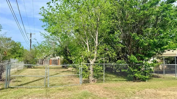 a view of a yard with wooden fence