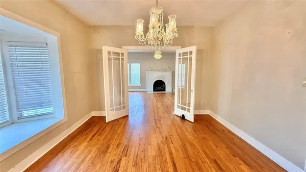 a view of a room with wooden floor a ceiling fan and windows