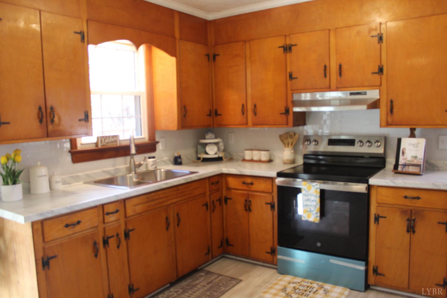 305 Eldon Road Appomattox, VA 24522 - Photo 15 of 24 a kitchen with a sink a stove and cabinets