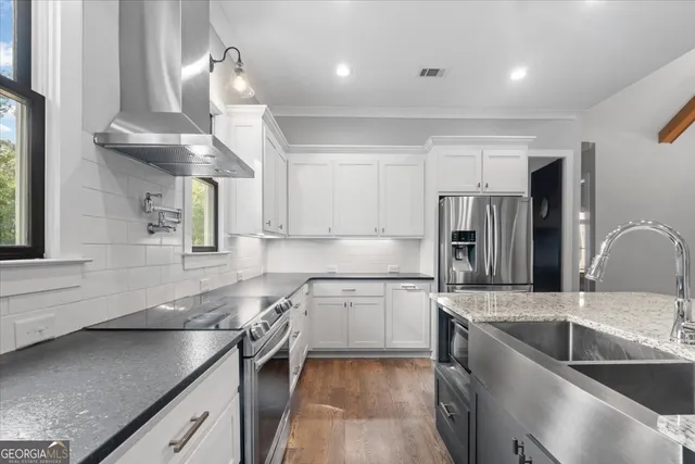 a dining room with wooden floor a chandelier a wooden table and chairs