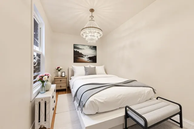 a bedroom with a bed and a chandelier