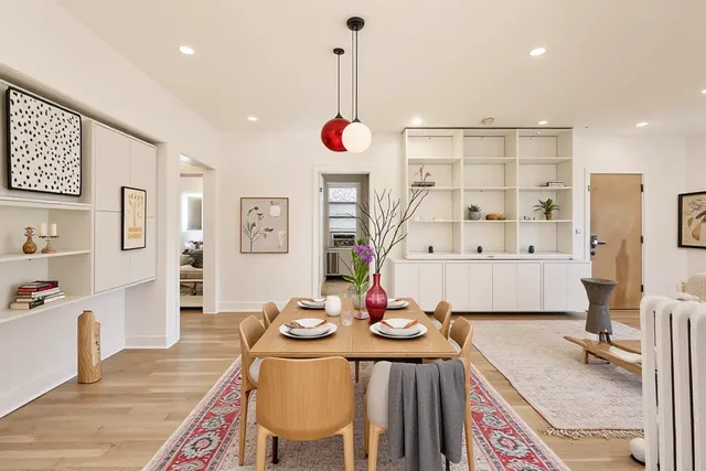 a kitchen with stainless steel appliances granite countertop a sink dishwasher and a dining table with wooden floor