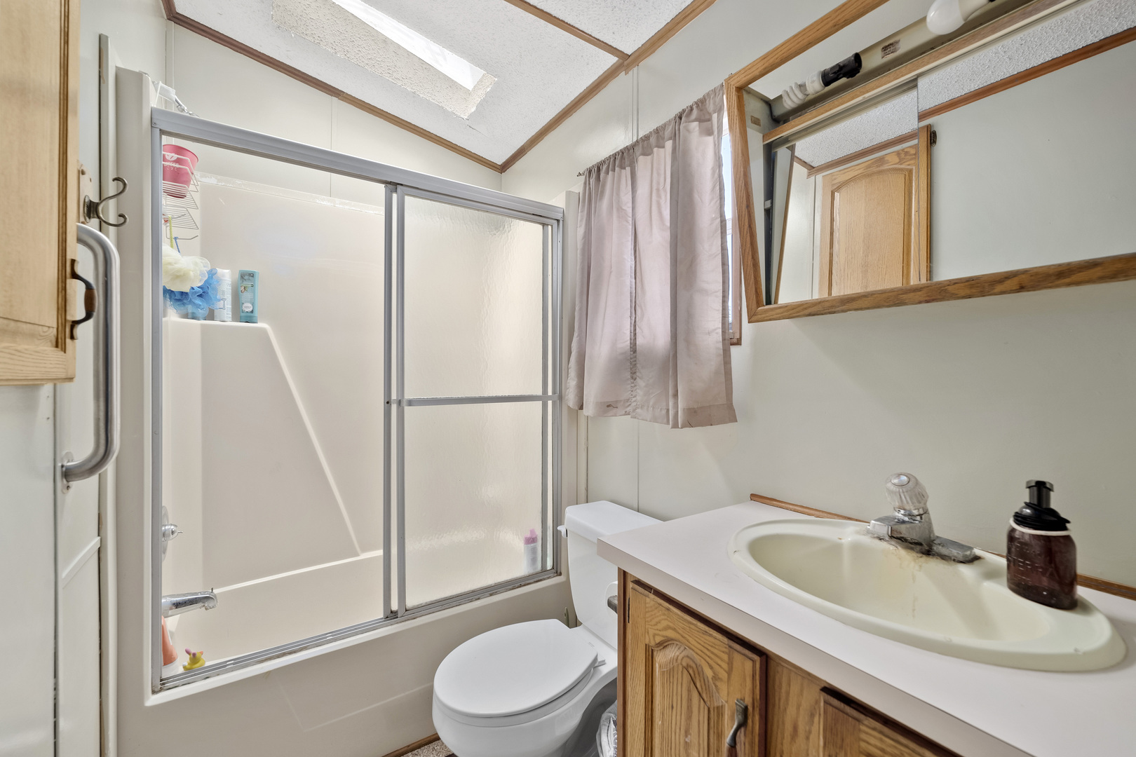 59 Dinosaur Road Wilmington, IL 60481 - Photo 10 of 17 a bathroom with a sink a toilet a mirror and shower