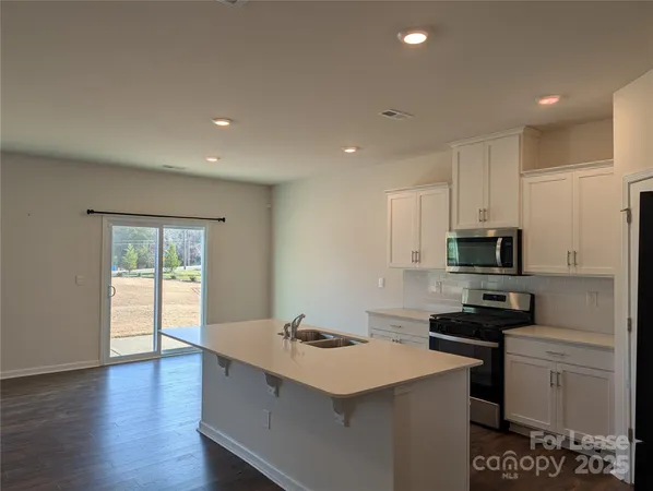 a kitchen with a sink a stove and cabinets