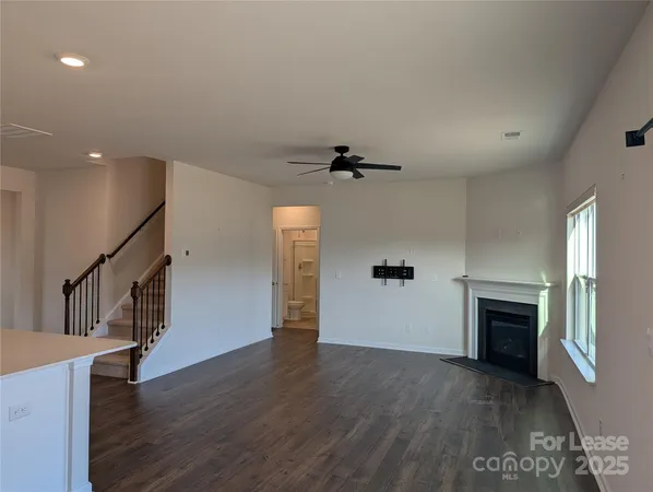 an empty room with wooden floor and fireplace