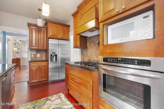 a kitchen with stainless steel appliances granite countertop a stove a refrigerator and a microwave