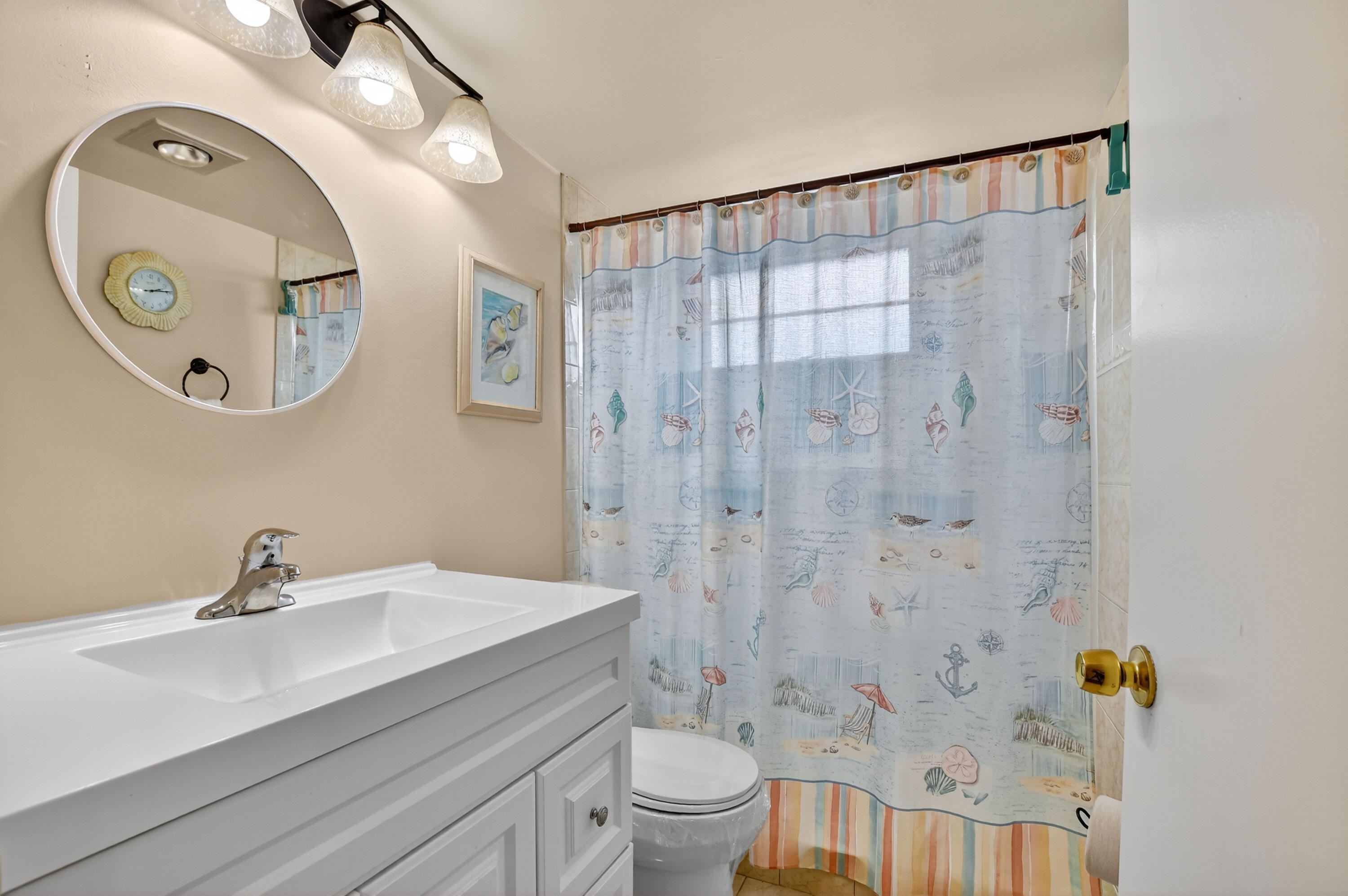 351 Fanshaw I Boca Raton, FL 33434 - Photo 12 of 28 a bathroom with a sink a mirror a toilet and a shower
