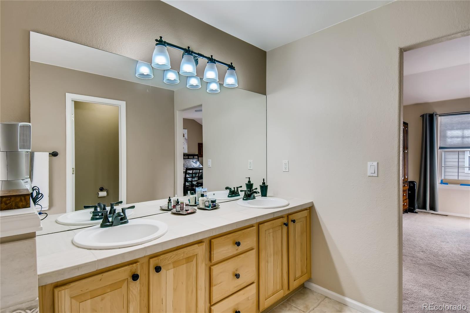 6214 Trailhead Road Highlands Ranch, CO 80130 - Photo 21 of 29 a bathroom with double vanity and a mirror