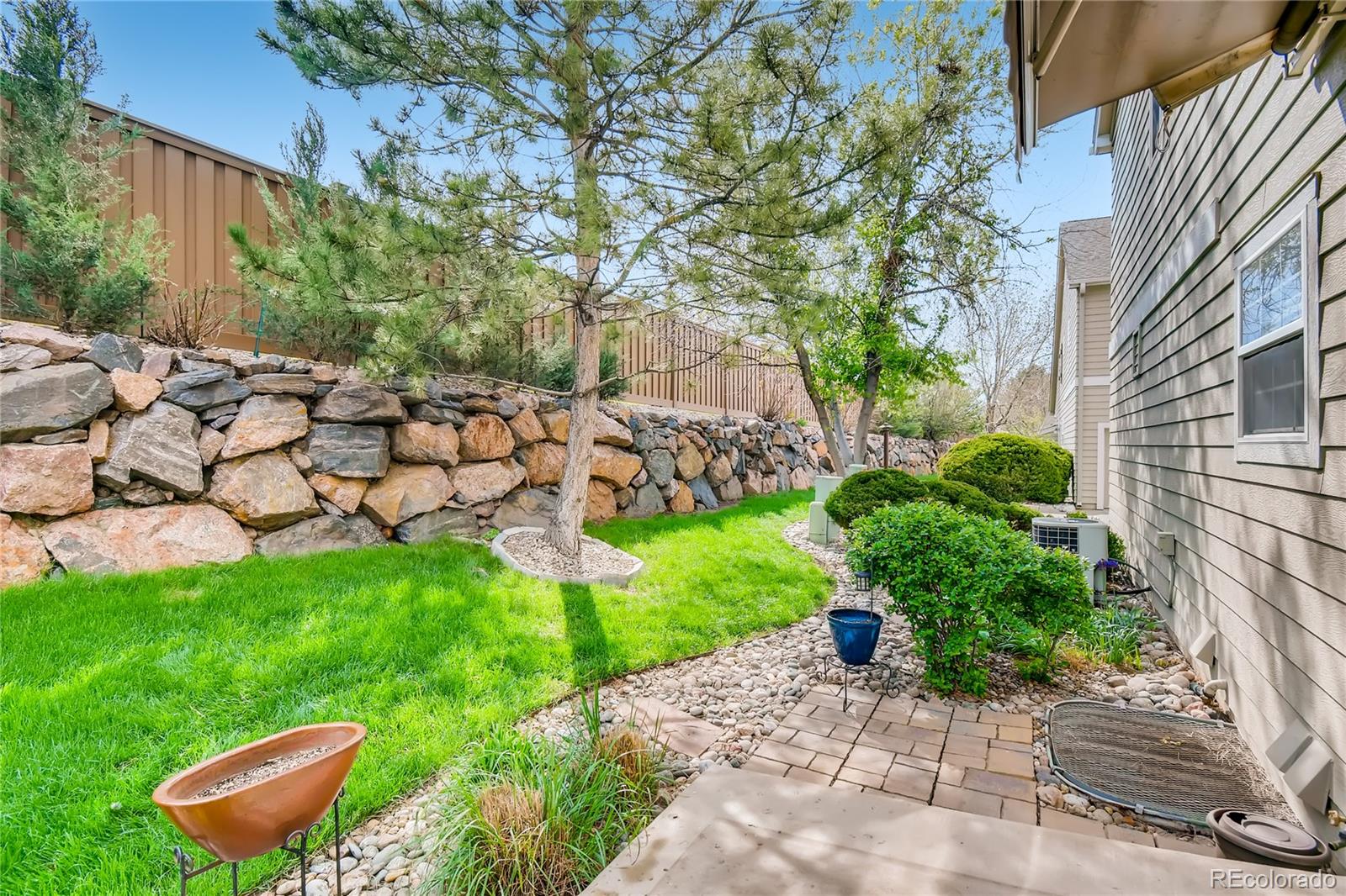 6214 Trailhead Road Highlands Ranch, CO 80130 - Photo 26 of 29 a garden with a bench and some trees