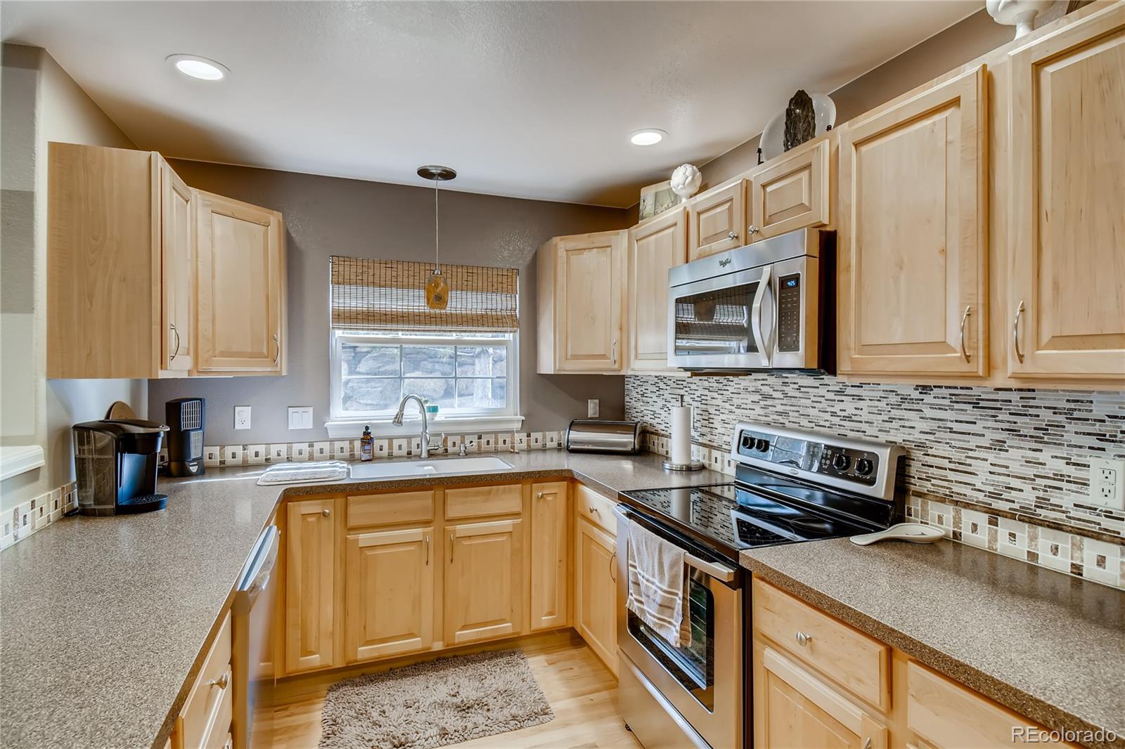 6214 Trailhead Road Highlands Ranch, CO 80130 - Photo 9 of 29 a kitchen with a sink stove and microwave