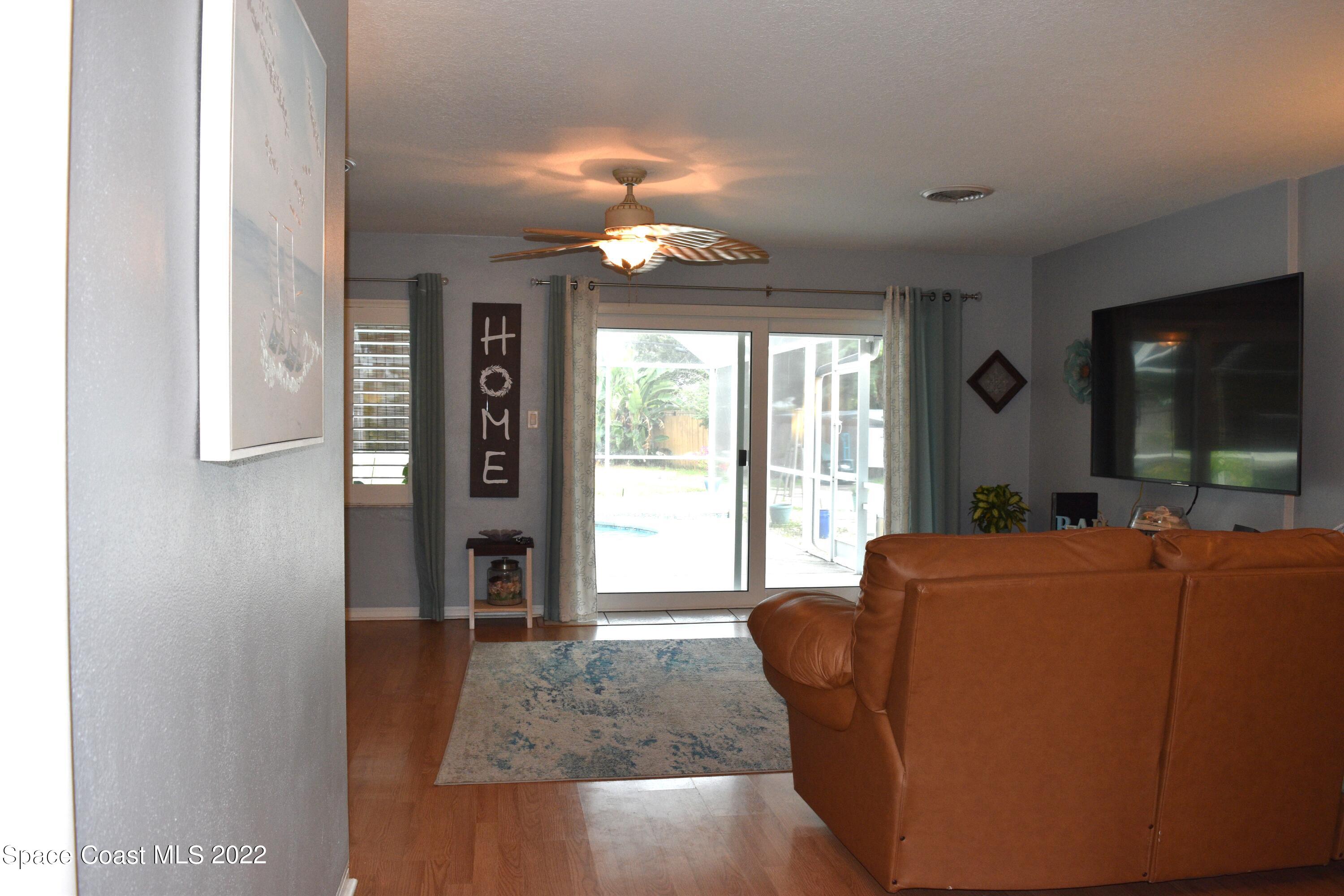 511 South Sonora Circle Indialantic, FL 32903 - Photo 3 of 10 a living room with furniture a flat screen tv and large windows