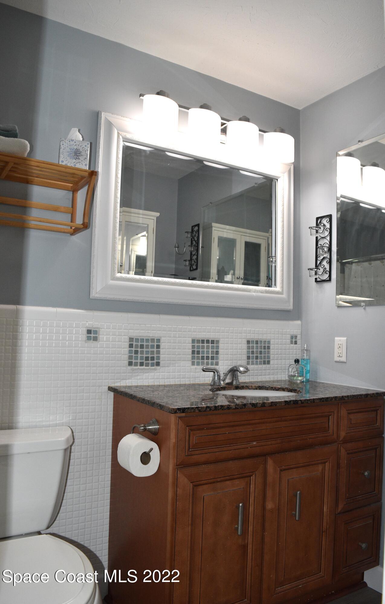 511 South Sonora Circle Indialantic, FL 32903 - Photo 8 of 10 a bathroom with a toilet sink and mirror