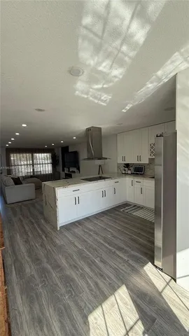 a kitchen with kitchen island a counter top a stove and a sink
