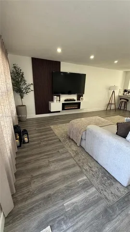 a spacious bedroom with a bed a couch and a flat screen tv