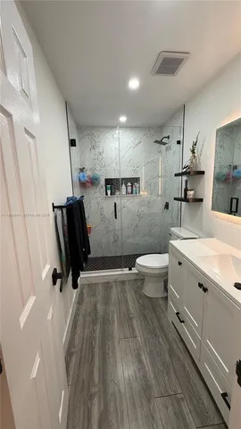 a bathroom with a sink toilet and shower