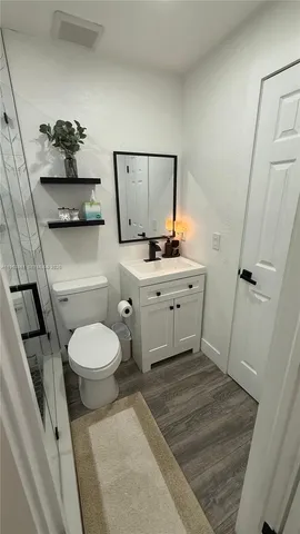 a bathroom with a sink a toilet and mirror