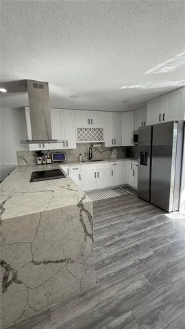 a kitchen with a sink a stove a refrigerator and cabinets