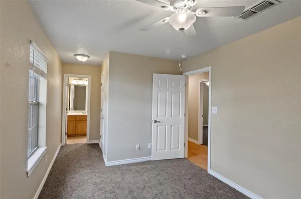 an empty room with fan and entrance