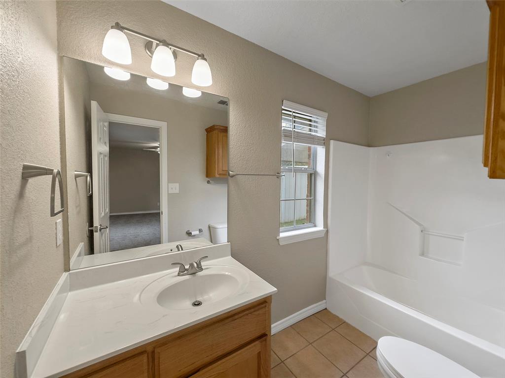 225 Oak Court, Unit 225 Rhome, TX 76078 - Photo 14 of 30 a bathroom with a sink a toilet and bathtub