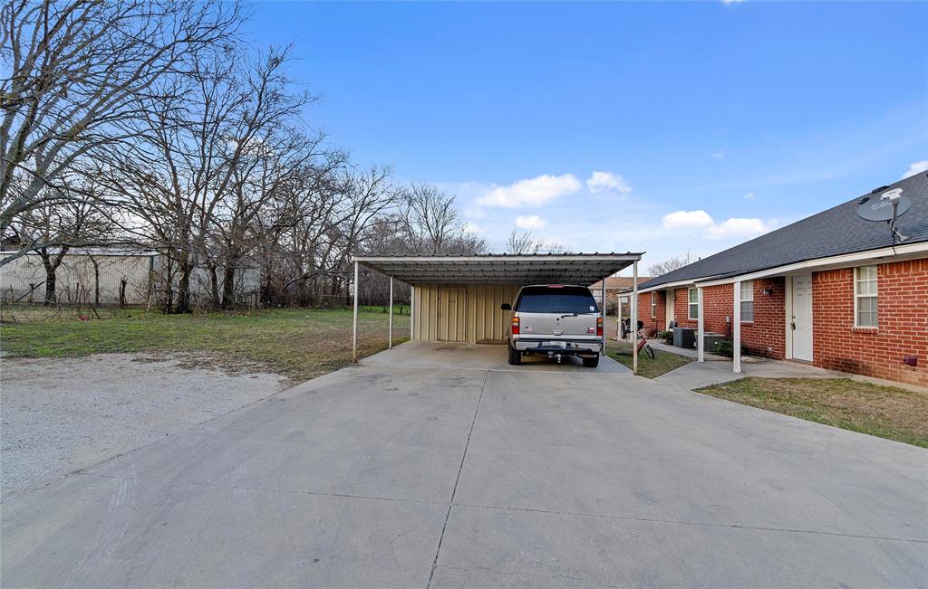 225 Oak Court, Unit 225 Rhome, TX 76078 - Photo 28 of 30 a view of a house with a yard and garage