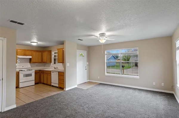 a view of a kitchen with a sink stove cabinets and entryway