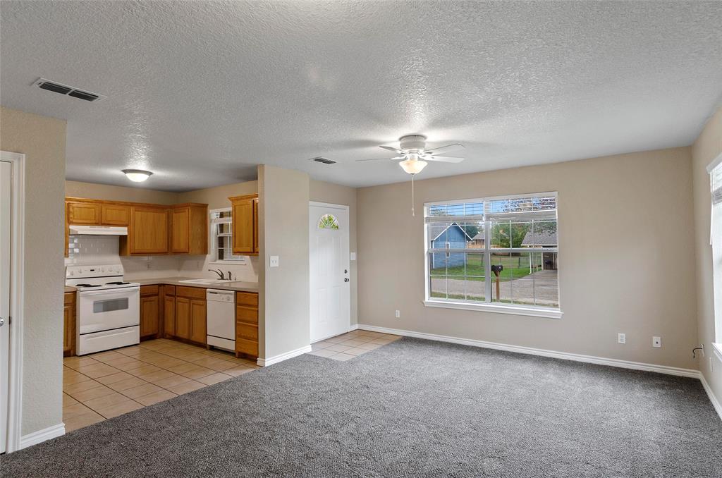 225 Oak Court, Unit 225 Rhome, TX 76078 - Photo 3 of 30 a view of a kitchen with a sink stove cabinets and entryway