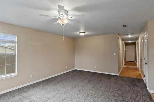 an empty room with fan and entrance
