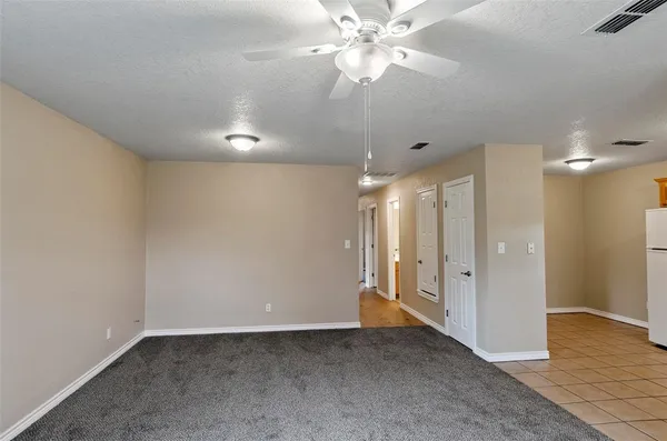 an empty room with fan and entrance